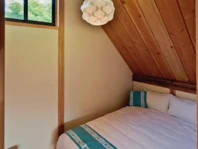bedroom with large windows in modern thatched roof villa Miyama Kyoto