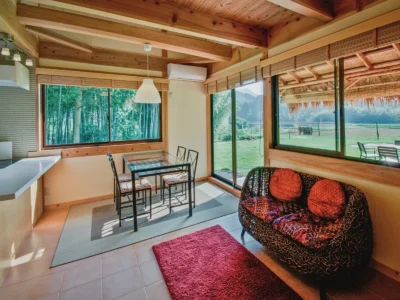 living and dining area with countryside view in thatched roof villa Miyama Kyoto