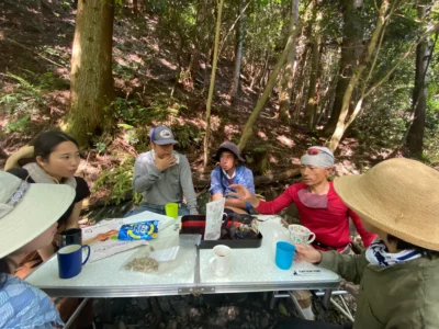 Thatching workers resting in the shade during summer at a Japanese thatched roof work site