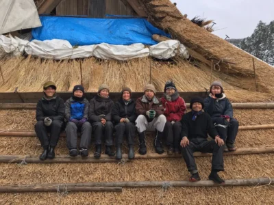 Haruo Nishio with young workers at a traditional thatched roof work site in Japan