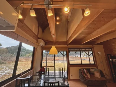 dining and living area with countryside view in thatched roof villa Miyama Kyoto