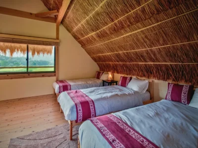 second floor bedroom with large windows in thatched roof villa Miyama Kyoto