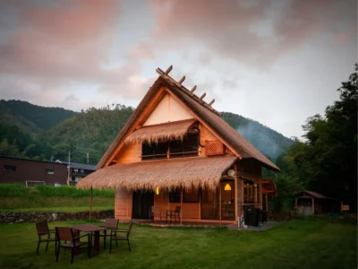 modern thatched roof villa exterior at summer dusk in Miyama Kyoto