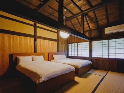 Bedroom with twin beds inside Mitoya thatched house in Miyama Kyoto