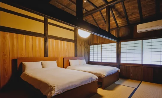Bedroom with twin beds inside Mitoya thatched house in Miyama Kyoto
