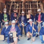 Guests placing thatch on a traditional roof in Miyama Kyoto