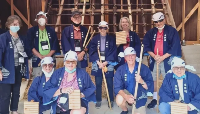 Guests placing thatch on a traditional roof in Miyama Kyoto