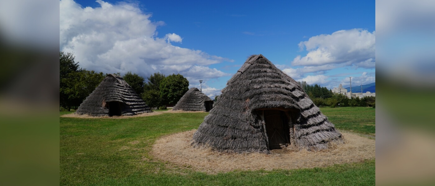 Reconstructed thatched-roof pit dwellings at the Hiraide archaeological site in Nagano, Japan