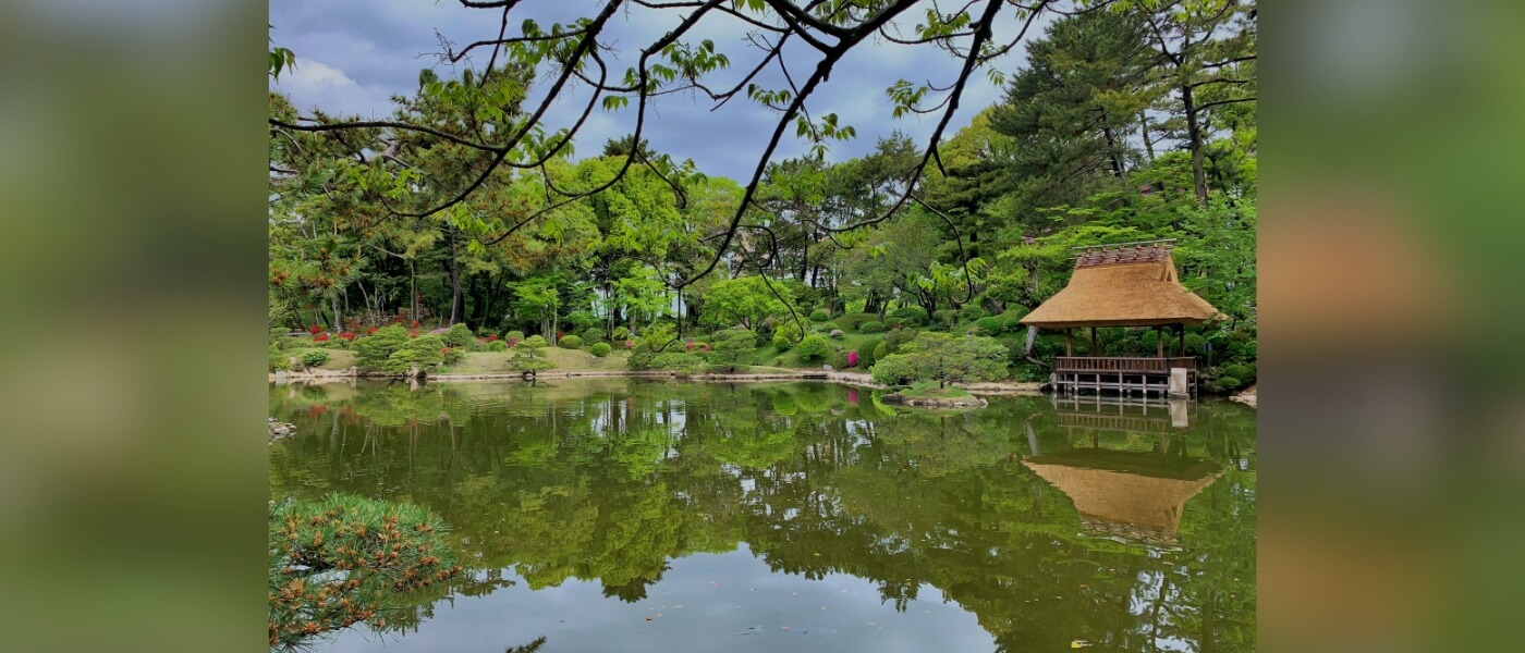 Traditional Japanese thatched-roof pavilion in Shukkeien Garden, Hiroshima